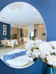 Căn hộ The Sóng Vũng Tàu في فنغ تاو: غرفة معيشة مع مرآة مستديرة وورود بيضاء