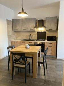 una cucina con tavolo e sedie in legno e una cucina con piano cottura di Wellhouse a SantʼAntìoco