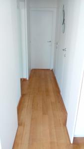 um corredor vazio com piso de madeira e armários brancos em Zoute penthouse (near place Albert) em Knokke-Heist