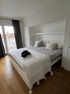um quarto com uma cama grande e um chapéu em Zoute penthouse (near place Albert) em Knokke-Heist
