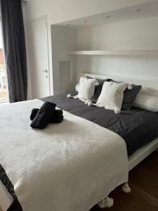 um quarto com uma grande cama branca e 2 almofadas em Zoute penthouse (near place Albert) em Knokke-Heist