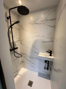 uma casa de banho branca com um lavatório e um chuveiro em Zoute penthouse (near place Albert) em Knokke-Heist