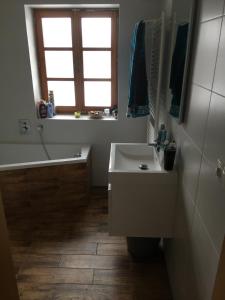 a bathroom with a sink and a tub and a window at U Rozlitýho mlíka in Chvaleč