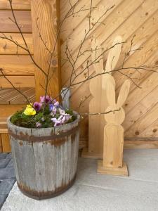 a large wooden pot with flowers in it next to a rabbit at Apartamenty Bąkowo Chatka in Witów