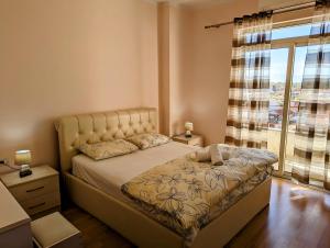 une chambre avec un lit et une grande fenêtre dans l'établissement Arbi's Apartment, à Shkodër
