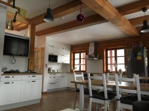 a kitchen with white cabinets and a table with chairs at U Rozlitýho mlíka in Chvaleč +3 photos