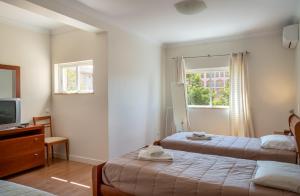 ein Hotelzimmer mit zwei Betten und einem Fernseher in der Unterkunft VILAMOURA Two Bedroom Near Praia Falésia in Quarteira