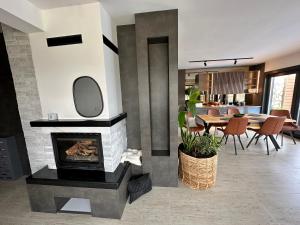 a living room with a fireplace and a dining room at Villa Coco in Sarajevo