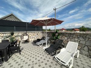 a patio with a table and chairs and an umbrella at Villa Coco in Sarajevo