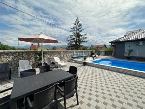 a patio with a table and chairs and a pool at Villa Coco in Sarajevo