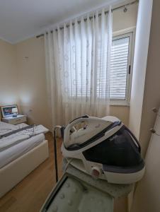 un lit d'hôpital dans une chambre avec fenêtre dans l'établissement Arbi's Apartment, à Shkodër 6 autres photos