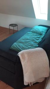 a bed with a blanket on it in a room at Neubau Ferienwohnung - Wallsbüll in Wallsbüll