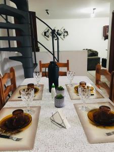 a table with plates and glasses on top of it at Excelente Apto a 2 km CENTRINHO TURÍSTICO in Campos do Jordão
