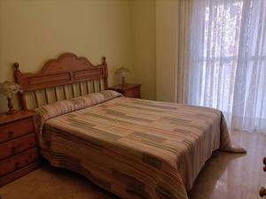 ein Schlafzimmer mit einem Bett, einer Kommode und einem Fenster in der Unterkunft apartamento céntrico en Lorca in Lorca