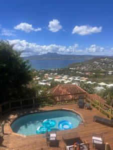 - une piscine sur une terrasse avec vue sur l'eau dans l'établissement F2 Résidence LE 25 ex PANORAMA, à Les Trois-Îlets