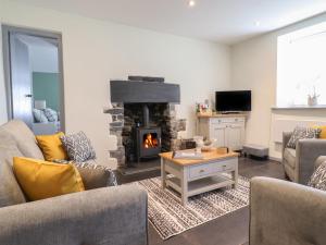 a living room with two couches and a fireplace at Arthurs Cottage in Tywyn
