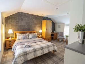 a bedroom with a bed with two slippers on it at Arthurs Cottage in Tywyn