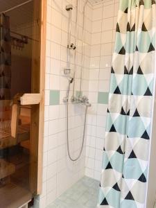 La salle de bains est pourvue d'une douche avec rideau de douche. dans l'établissement Rovaniemi City Centre Apartment, private sauna, à Rovaniemi