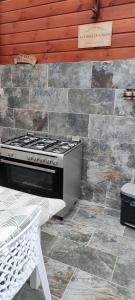 a stove in a kitchen with a stone wall at Villa Mary Guest House in Saint-André