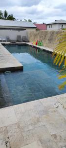 basen z błękitną wodą na dziedzińcu w obiekcie Villa Mary Guest House w mieście Saint-André