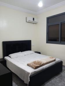 - une chambre avec un lit doté d'une tête de lit noire et d'une fenêtre dans l'établissement Lotissement melouiya GUERCIF Maroc, à Guercif