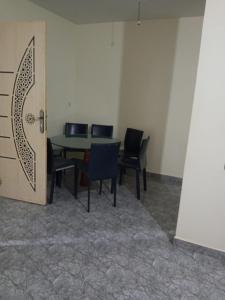 - une chambre avec une table, des chaises et une porte dans l'établissement Lotissement melouiya GUERCIF Maroc, à Guercif
