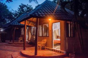 a small house with a porch and a bedroom at Kijani Cottages - In Diani in Diani Beach