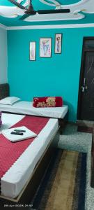 um quarto com duas camas e uma parede azul em Vasudev Lodging em Chamoli