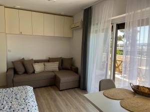 - un salon avec un canapé et une fenêtre dans l'établissement Marina Mirage Apartments, à Sukošan