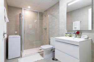 a bathroom with a shower and a toilet and a sink at Dorm4You Arena Standar Junior in Valencia