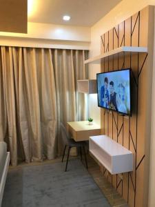 um quarto com uma televisão numa parede com uma secretária em Executive Traveller em Iloilo