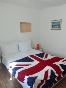 a bedroom with a british flag blanket on a bed at ROSE COTTAGE (sleeps 4) in Chlum u Třeboně