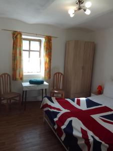 a bedroom with a bed and a table and a window at ROSE COTTAGE (sleeps 4) in Chlum u Třeboně