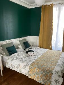 łóżko w pokoju z zieloną ścianą w obiekcie Cosy appartement in Paris w Paryżu