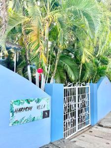 una cerca azul con una puerta frente a las palmeras en Harmony 2BHK Homestay by Goaround Homes en Vagator