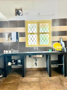 encimera de cocina con fregadero y ventana en Harmony 2BHK Homestay by Goaround Homes en Vagator