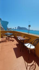 two tables and chairs on a balcony with the ocean at Gibraltar Views Guest House in La Línea de la Concepción