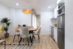 a kitchen and dining room with a table and chairs at Dorm4You Arena Plaza in Valencia