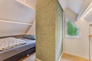 um pequeno quarto com uma cama e uma janela em Luxe Bos bungalow met Airco em Posterholt