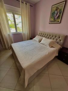 ein Schlafzimmer mit einem großen Bett in einem Zimmer in der Unterkunft Esmeralda Apartaments in Sarandë + 25 Fotos