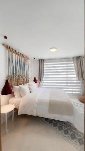 a white bedroom with a large bed and a window at Sabbia By LD Hoteles in El Roque