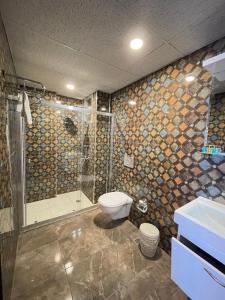 een badkamer met een douche, een toilet en een wastafel bij İkarus Hotel in Kuşadası