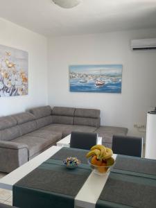 ein Wohnzimmer mit einem Sofa und einem Tisch mit Bananen darauf in der Unterkunft Kuća za odmor Denona in Borovići