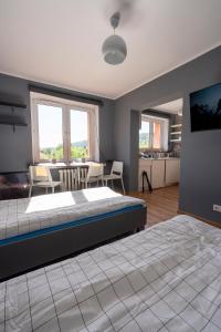 a bedroom with a large bed and a dining room at Apartament w Karkonoszach in Piechowice