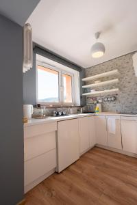 a kitchen with white cabinets and a window at Apartament w Karkonoszach in Piechowice