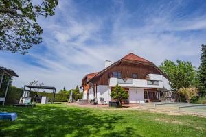 duży biały dom z dachem gambrel w obiekcie Villa mit Pool und Garten w mieście Thalheim bei Wels