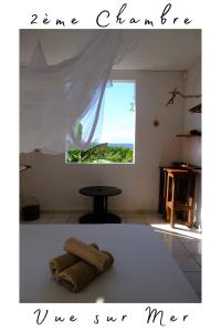 a white room with a table and a window at La Casa des Lucioles in Saint-Louis