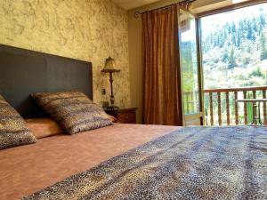 a bedroom with a large bed with a large window at Hotel Finca Malvasia in Cabezón de Liébana