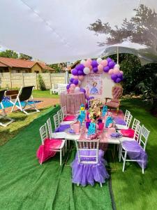 stół z fioletowymi i różowymi dekoracjami i balonami w obiekcie Horizon Garden Party & Events Venue w mieście Randfontein