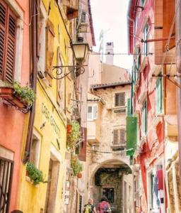 an alley in a city with people walking down it at Dolce Studio Apartmani in Rovinj